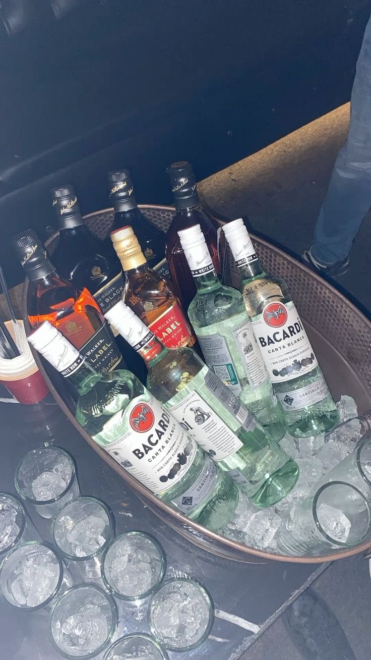 Bottles chilling in ice beside empty glasses
