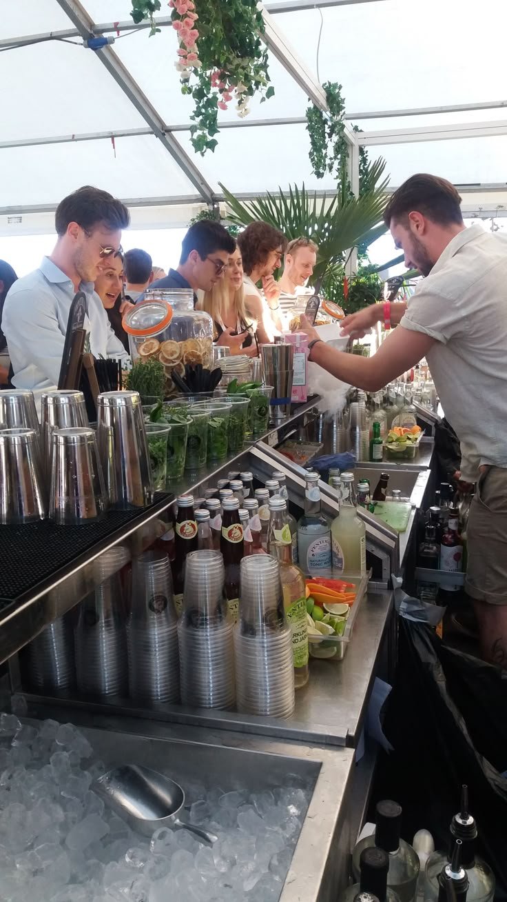 A working bar under a tent with ice and glassware